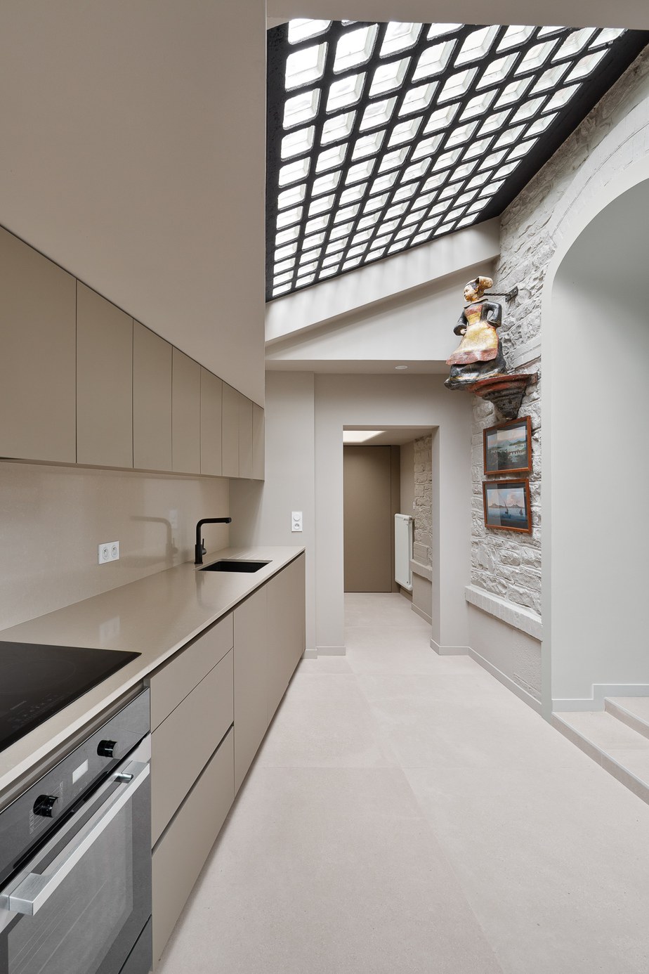 Photographie appartement Rennes : espace cuisine & salle à manger avec cuisine en agencement laquée Kaki, plan de travail en pierre Cheyenne avec plaque de cuisson Bora, parquet refait à neuf, table à manger ronde blanche et chaises jaunes, suspension Vibia Duo blanche et bois au-dessus, enfilade ancienne chiné / l'ensemble est ouvert sur le salon